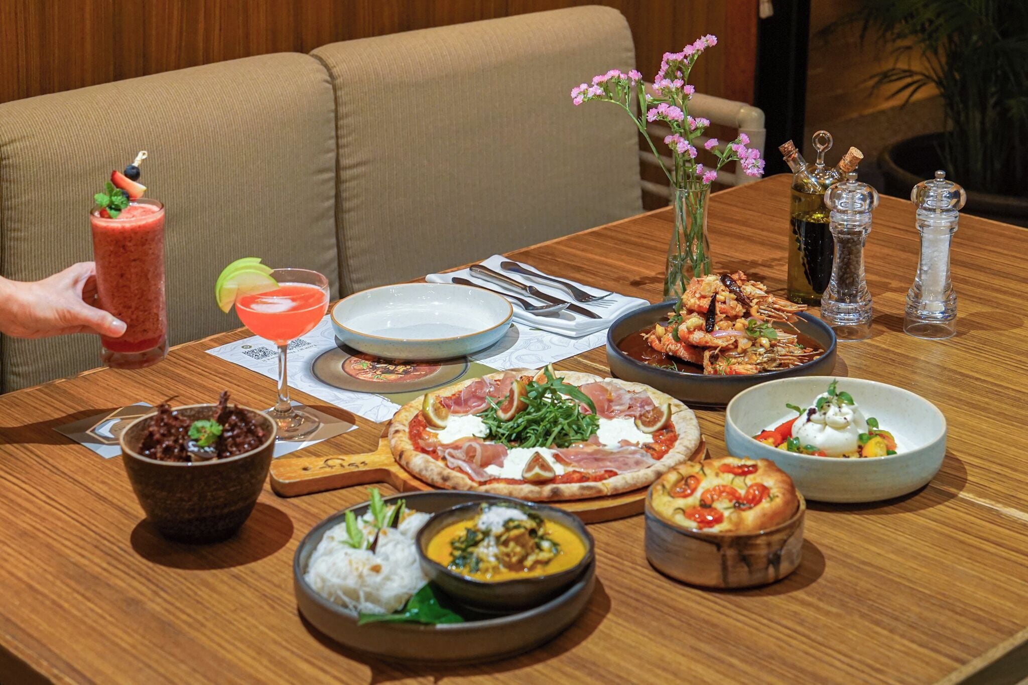 Una mesa de comedor con diversos platos, como pizza, sopa y ensalada.