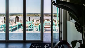 Entrada de hotel com vista para área de estar ao ar livre e uma grande janela.