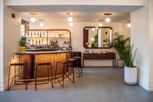 Un moderno espacio de bar con taburetes, una barra y una variedad de botellas.