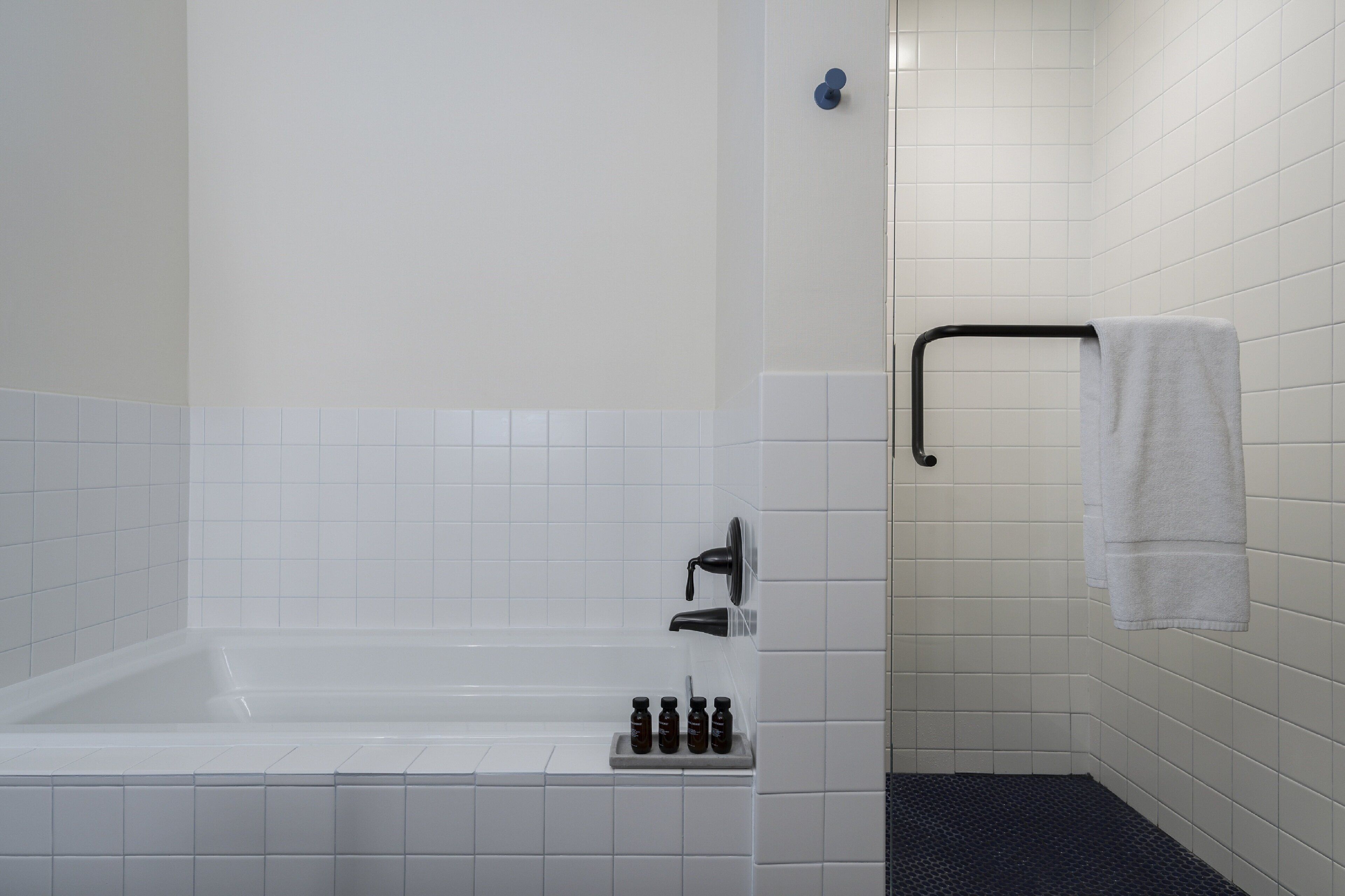 Un baño con bañera, ducha y barra para toallas.