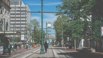 A street with buildings, a clock tower, and a tram line.