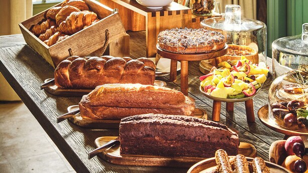Un bufé de desayuno con diversos pasteles, frutas y postres.