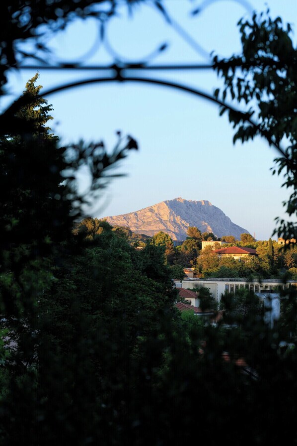 A mountain with a clear sky, surrounded by trees and buildings.