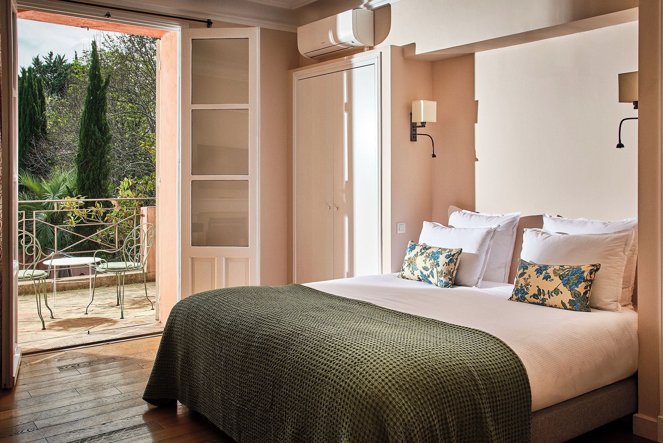 Une chambre à coucher avec un lit, une fenêtre et une porte donnant sur un balcon.