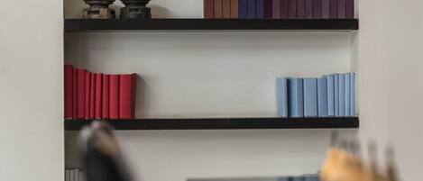 Una estantería moderna con varios libros y objetos decorativos.
