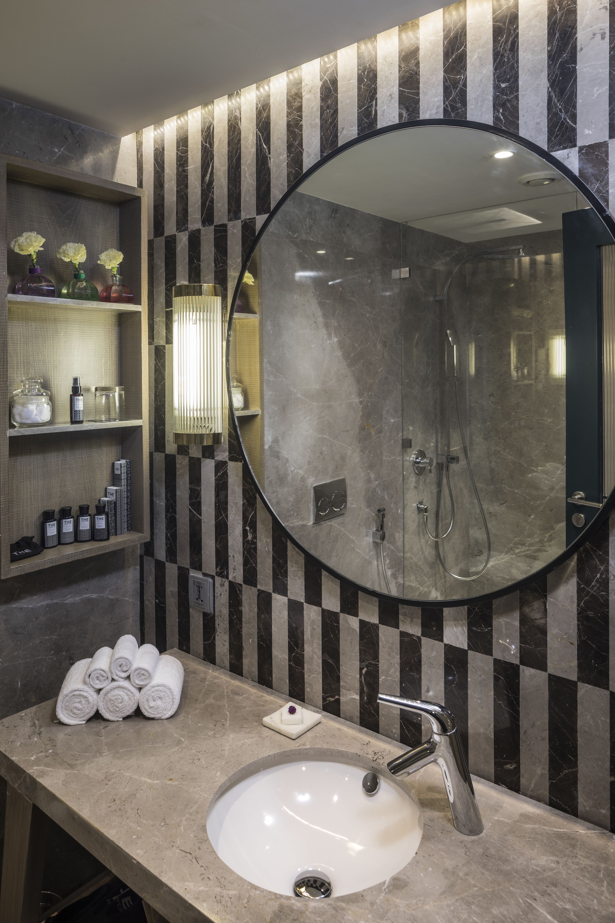 A bathroom with a marble sink, a large mirror, and a shower.