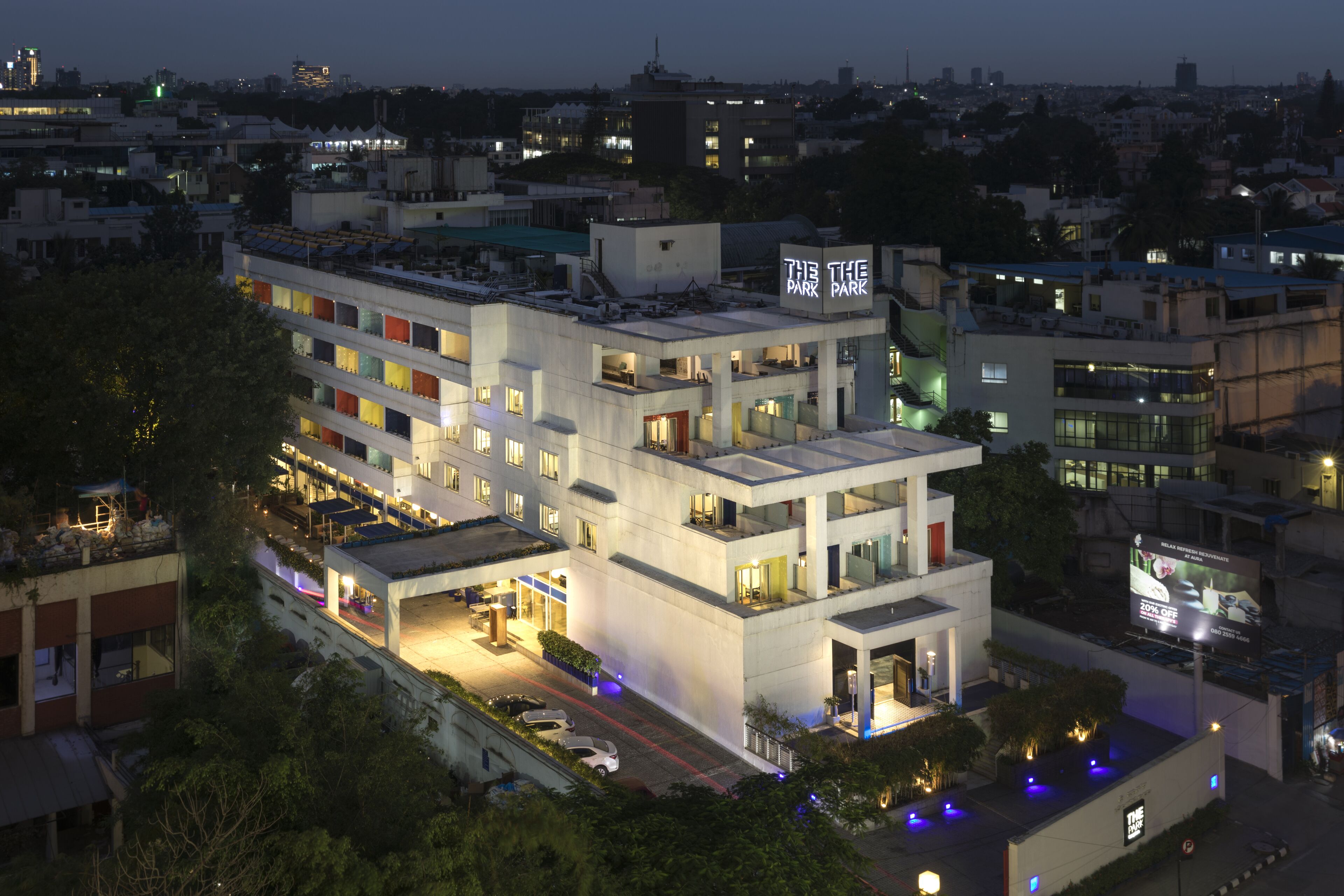 A modern hotel with multiple floors, a rooftop terrace, and a sign reading "The Park."