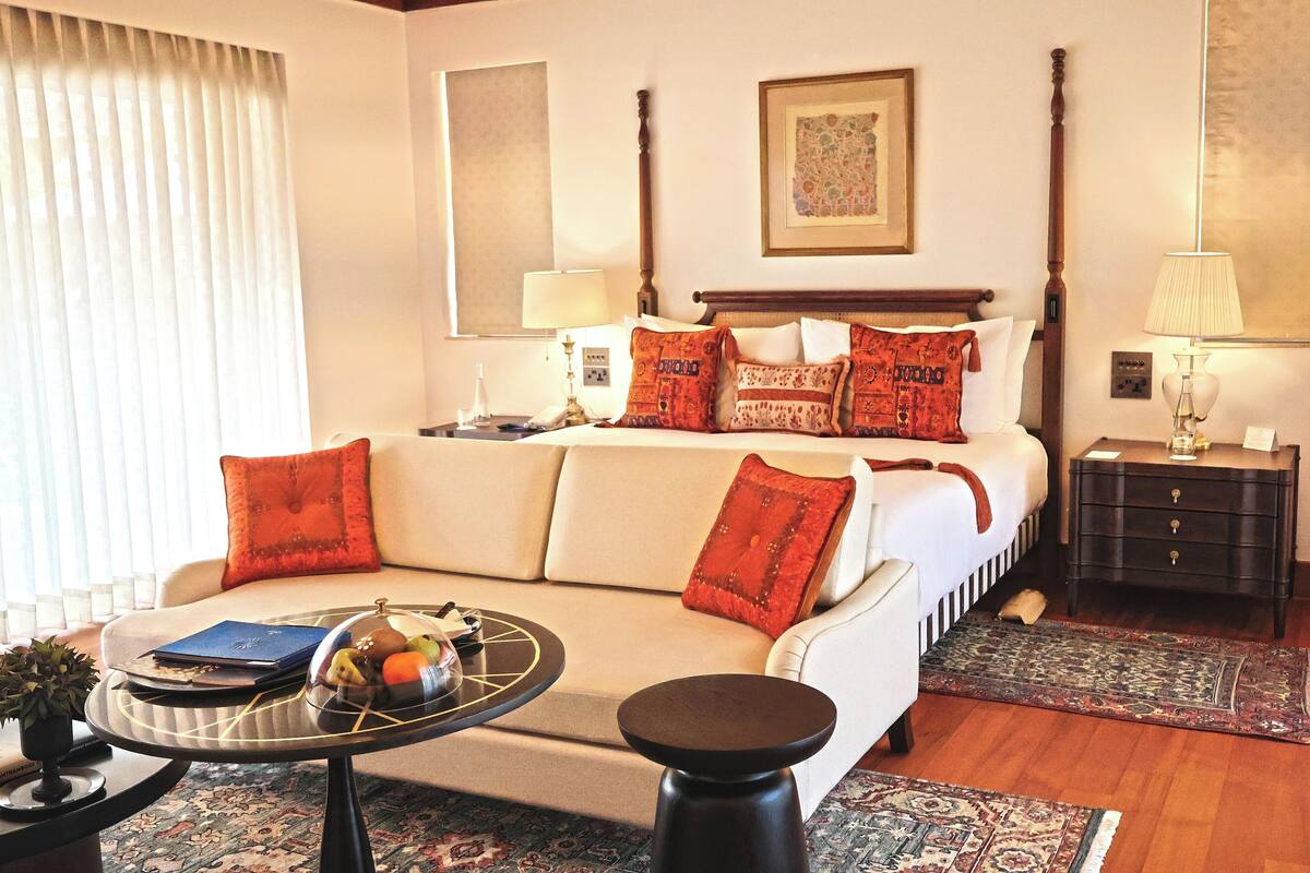 Une chambre d’hôtel comprenant un lit, un canapé, une table basse, une table d’appoint et une lampe.