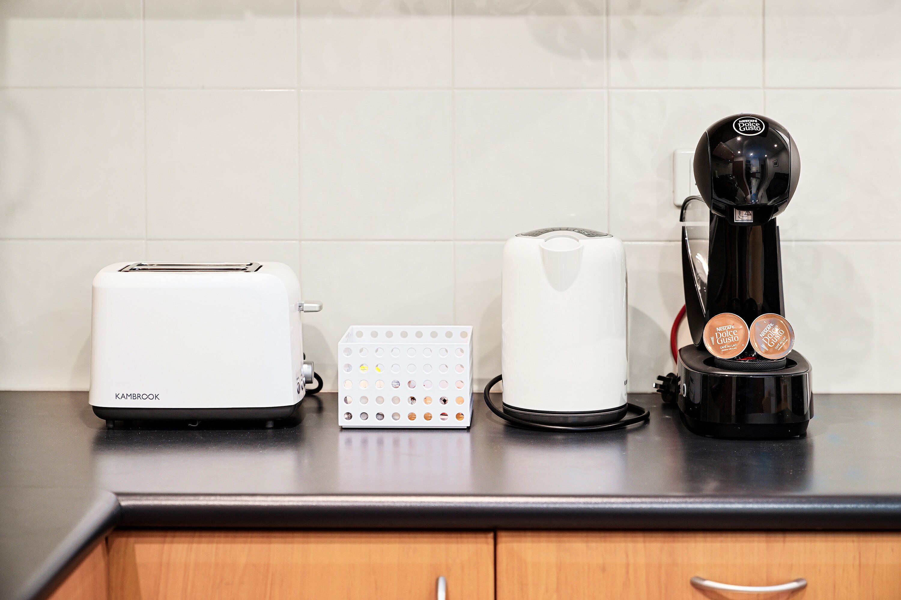 A kitchen counter with a toaster, a coffee maker, and a coffee pod holder.