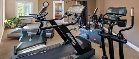 A home gym with various exercise equipment including treadmills, a stationary bike, and a rowing machine.