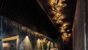 A modern lobby with seating areas, a textured wall, and a patterned ceiling. - Radisson Blu Carlton Hotel, Bratislava (Bratislava)