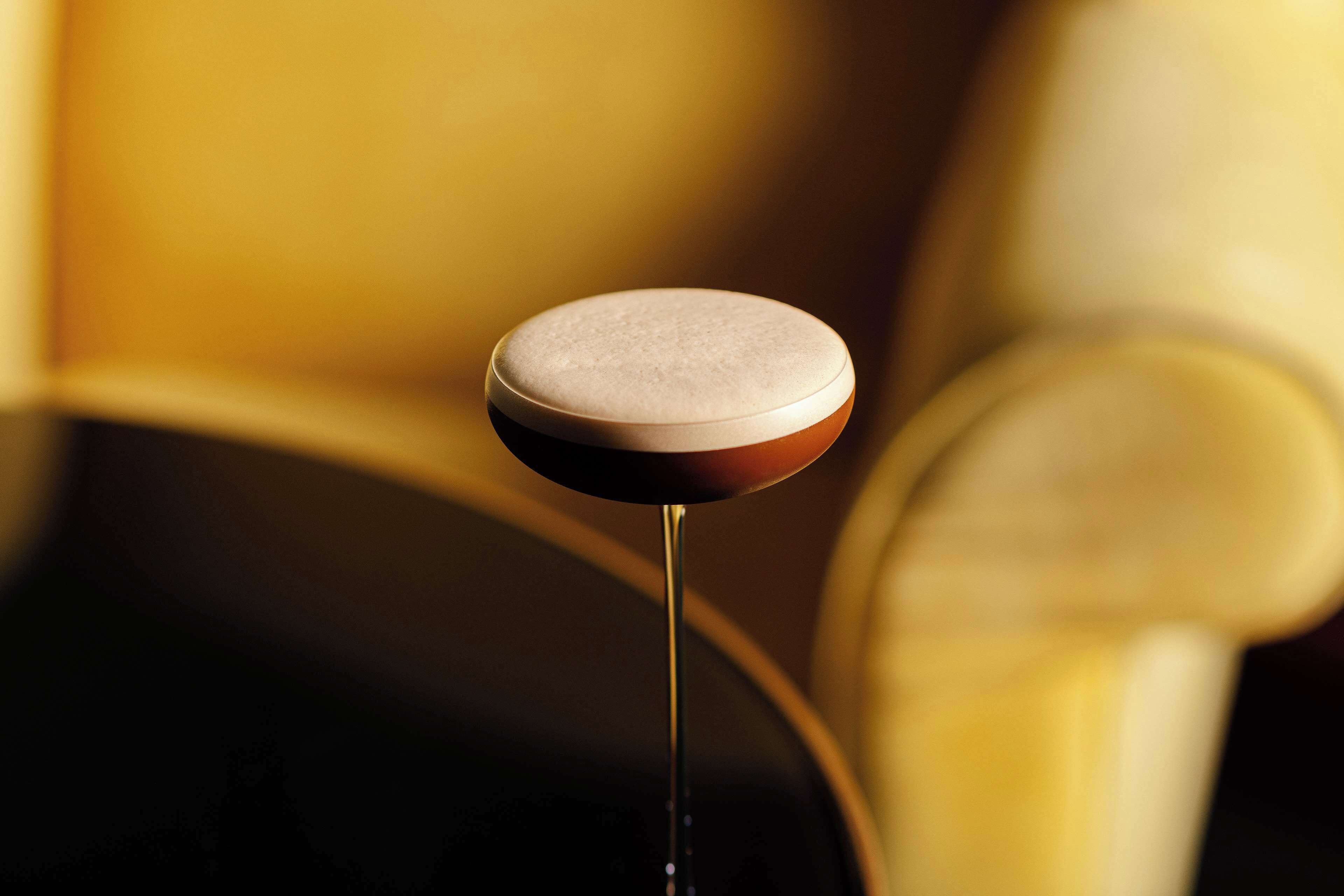 A close-up of a round, flat object with a reflective surface, possibly a button or a knob, on a stand with a thin, straight pole.