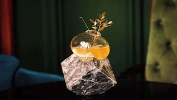 Un florero de vidrio transparente con una planta sobre un pedestal de mármol.