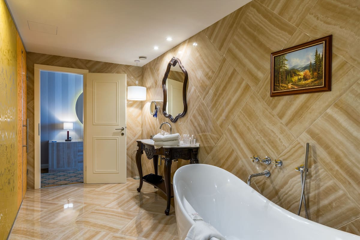 junior suite | bathroom | combined shower/bathtub, deep-soaking bathtub, free toiletries
