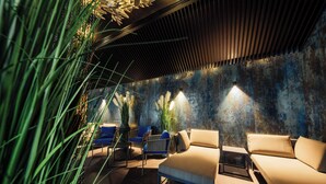 A modern lounge with a sofa, chairs, and a decorative wall. - Radisson Blu Carlton Hotel, Bratislava (Bratislava)
