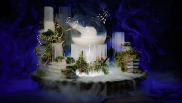 Une coupole de verre à l’intérieur blanc, entourée de verdure et de brume.