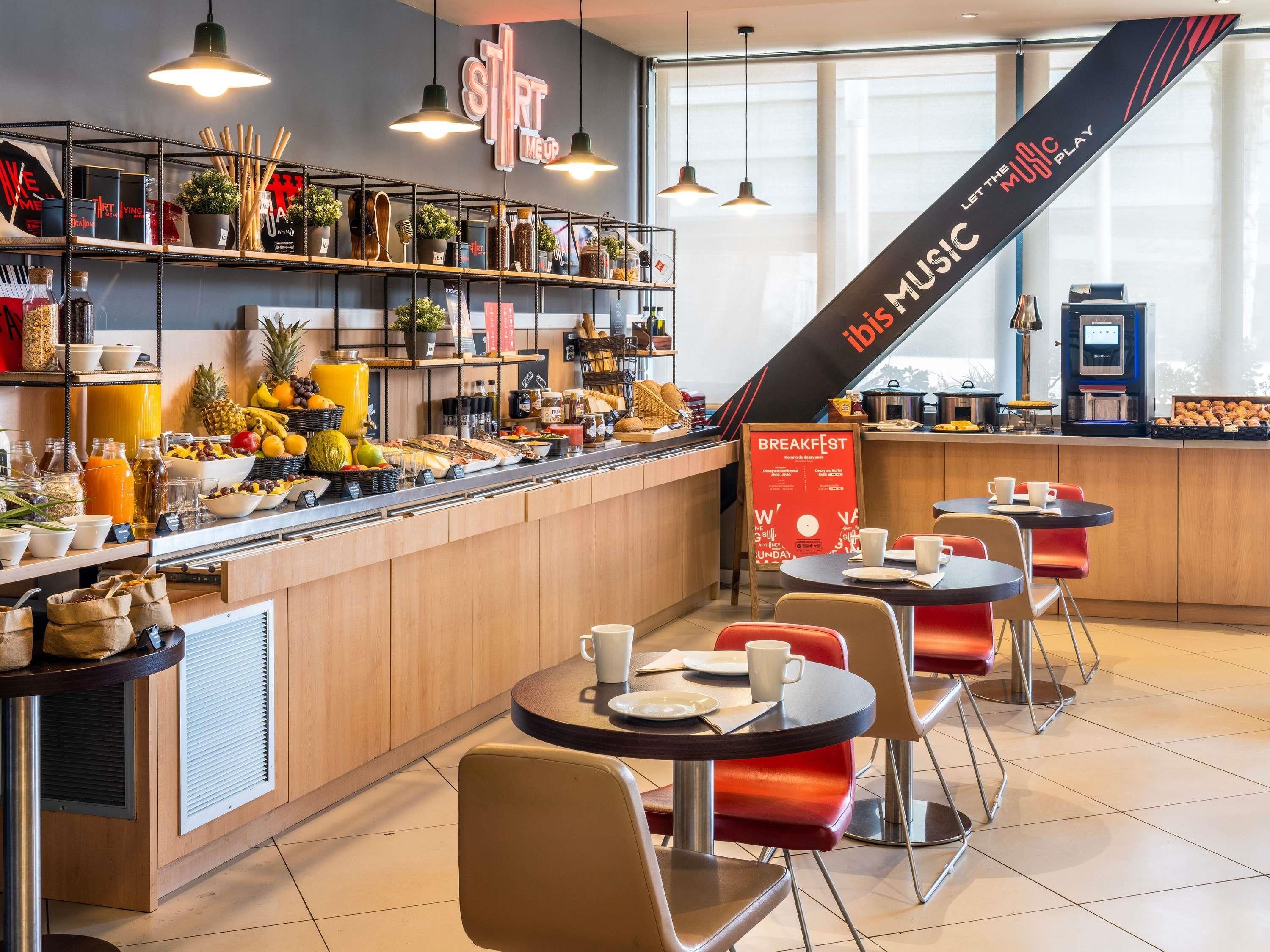 A breakfast bar with a variety of food items and a sign indicating breakfast hours.