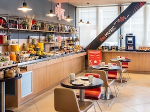 A breakfast bar with a variety of food items and a sign indicating breakfast hours. - ibis Barcelona Meridiana (Barcelona)
