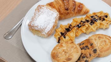 A plate with pastries and a cup of coffee on a table.