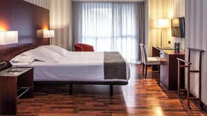 A hotel room with a bed, bedside tables, a desk with a chair, a TV, and a window with curtains. - Hotel RH Murcia Centro By Hoteles RH (Murcia)