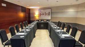 A conference room with a long table, chairs, and a projector screen. - Hotel RH Murcia Centro By Hoteles RH (Murcia)