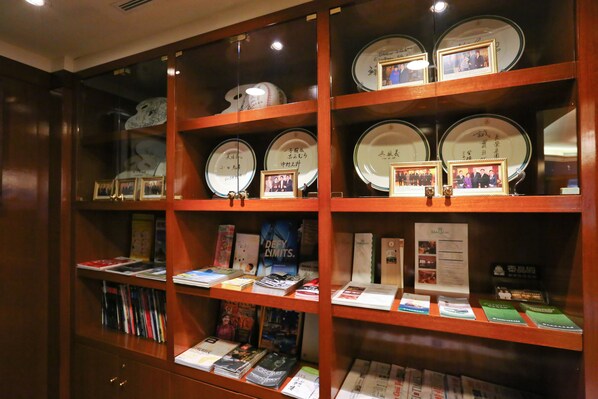 Una exposición de libros y fotografías enmarcadas en estantes.
