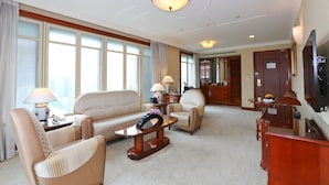 A hotel room with a sofa, armchairs, a coffee table, a TV, and a dining area with a table and chairs. - Evergreen Laurel Hotel Taipei (Taipei)