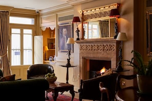 A traditional living room with a fireplace, leather furniture, and a large window. - Hazlitt's Hotel (London)