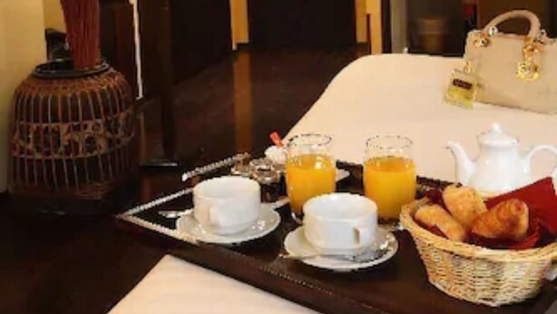 A hotel room with a breakfast tray, a lamp, and a bed. - Le Boutique Hôtel Garonne by Occitania hotels (Toulouse)