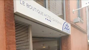 The entrance to Le Boutique Hotel Garonne with a glass door and a metal shutter. - Le Boutique Hôtel Garonne by Occitania hotels (Toulouse)