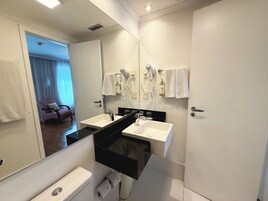 Un bagno moderno con due lavabi, uno specchio e un asciugacapelli.