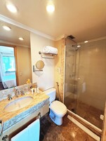Un bagno con lavandino, WC e cabina doccia in vetro.