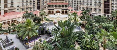 A large atrium with multiple floors, balconies, and lush greenery.
