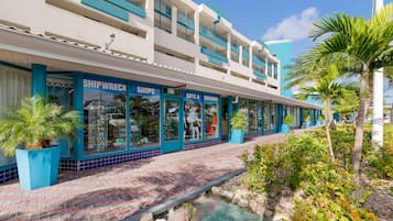 Un hôtel à la façade bleue et blanche, qui comprend des boutiques et une boutique de souvenirs.
