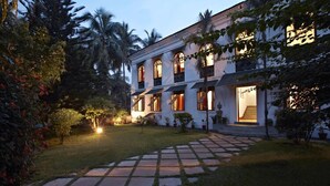 A two-story building with a garden pathway leading to the entrance. - Siolim House (Siolim)