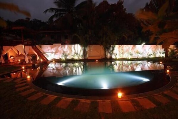 A pool with a circular edge and a surrounding deck area.