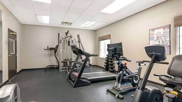 A gym with cardio equipment, weight machines, and a treadmill.