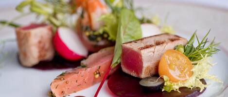 Un plato con varios ingredientes, incluyendo carne, verduras y salsa.