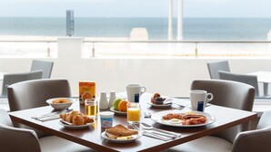 A breakfast table with various food items and a view of the ocean. - Best Western Carlton Hotel (Blackpool)