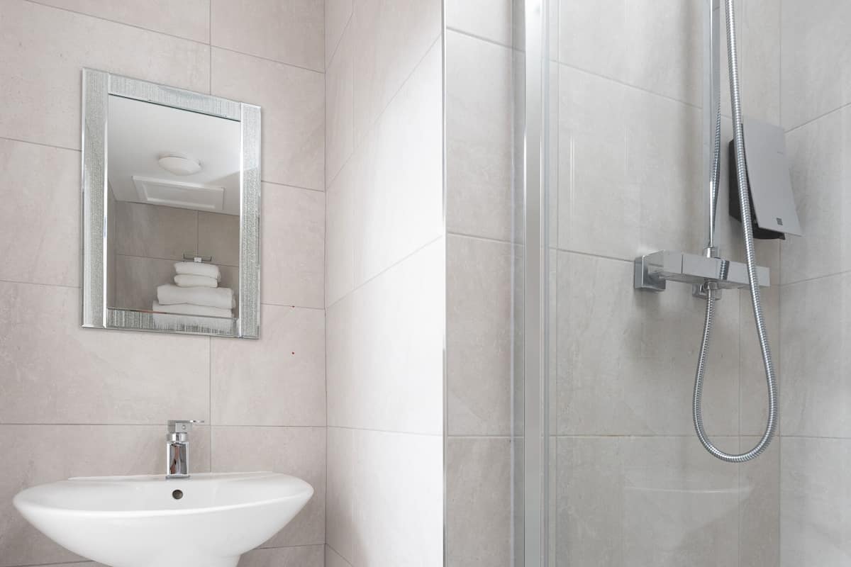 Shower, designer toiletries, hair dryer, towels