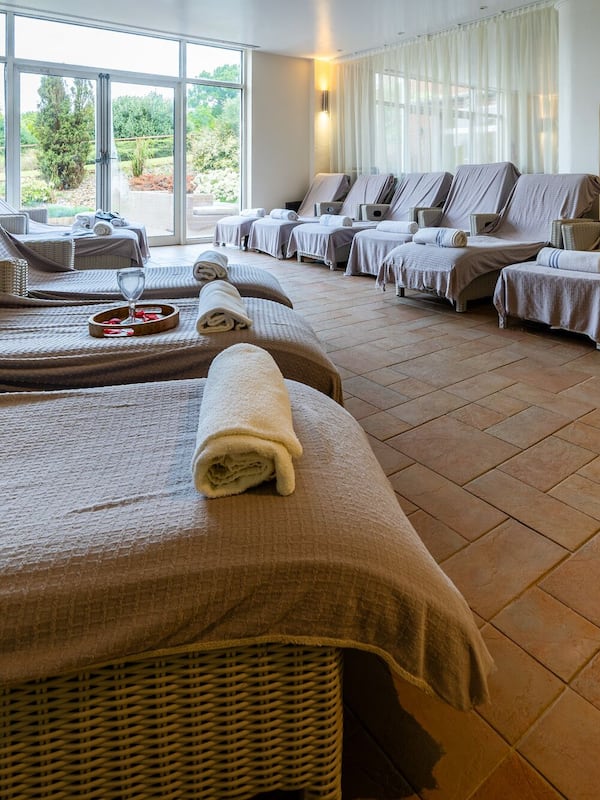 Relax in a serene spa room with massage chairs, a view of the lush garden, and a convenient floor layout.