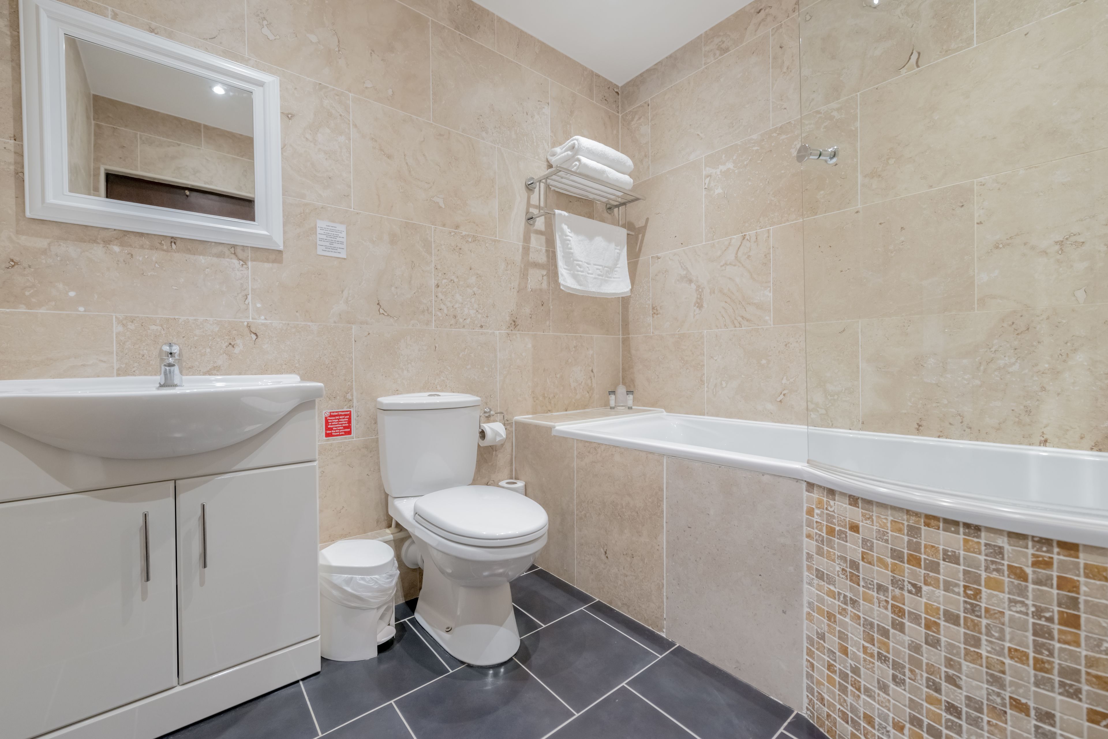 A modern bathroom with a sink, toilet, and bathtub.