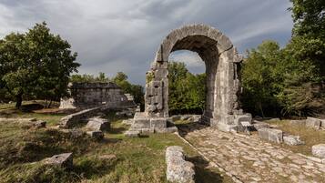 Ruinas antiguas con estructuras de piedra y un arcoado.