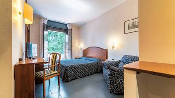 Una habitación de hotel con cama, escritorio, silla y sofá.