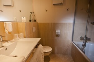 Uma casa de banho com lavatório, sanita e chuveiro.