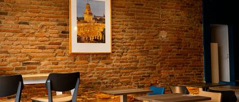 A restaurant with brick walls, framed pictures, and modern seating.