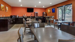 Un restaurant moderne doté d’un espace cuisine, de tables et de chaises.