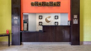 Un comptoir d’accueil au design moderne, un guichet d’enregistrement et un panneau fixé au mur.