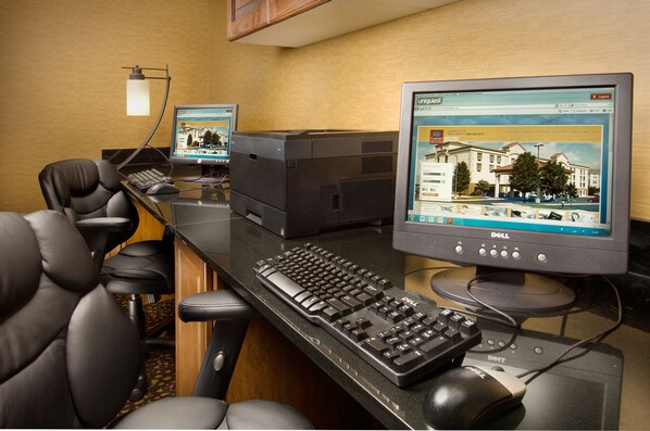 A hotel room with a desk, two monitors, a keyboard, a mouse, and a leather chair. - Comfort Suites Dulles Airport (Chantilly)