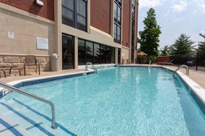 A swimming pool with a metal handrail, adjacent to a building with large windows and a brick facade. - Drury Inn & Suites Nashville Airport (Nashville)